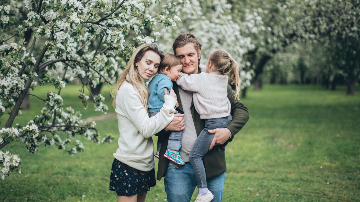 an embraced family of four by a tree dealing with the challenges of dysfunctional families
