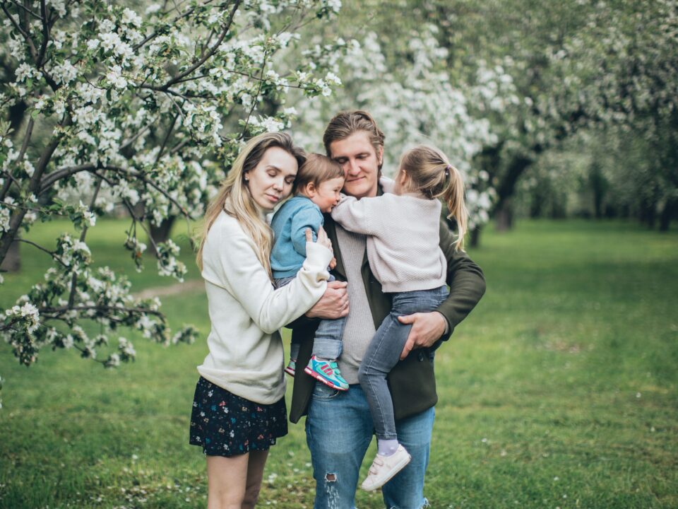 an embraced family of four by a tree dealing with the challenges of dysfunctional families