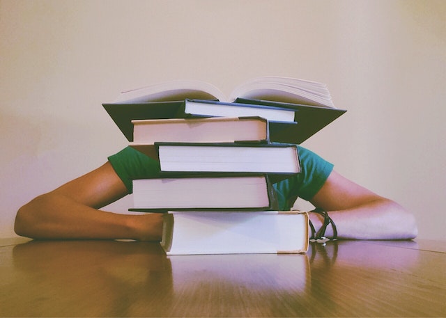 Books on the table and the man behind.