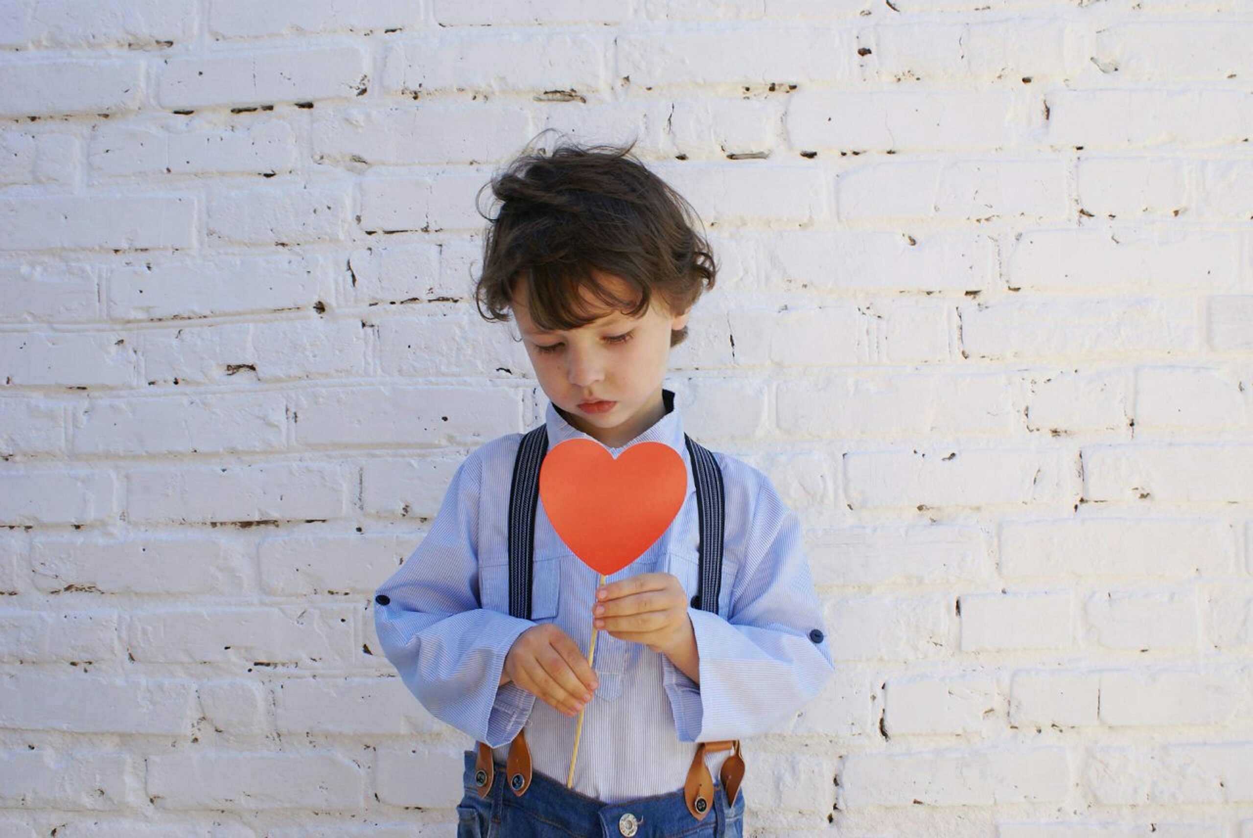 a boy holding a cardboard heart